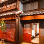 Nagasaki Museum of History and Culture (長崎歴史文化博物館) A traditional Japanese wooden building with sliding lattice doors, wooden beams, tiled roof, and bamboo plants near the entrance, reminiscent of the architecture showcased at the Nagasaki Museum of History and Culture, seen in a well-lit indoor setting.