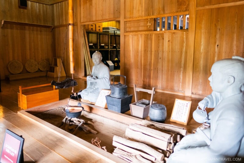 A room with a table displaying a statue and objects, reminiscent of exhibits at the Hakone Checkpoint Museum.
