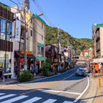 Hakone-Yumoto Station (箱根湯本駅) – Gateway to Hakone’s Hot Springs A street in hakone-yumoto with buildings and cars on it.