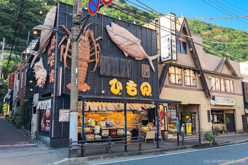 A building with a sign on the side stands in the heart of Hakone-Yumoto.