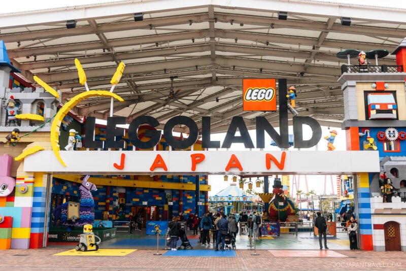 The entrance to LEGOLAND Nagoya features a large sign with colorful LEGO bricks, playful LEGO figures, and a bright open canopy. Visitors stroll into the amusement park—an iconic spot in any Nagoya travel guide.