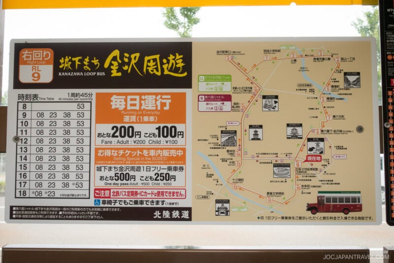 A sign displays the Kanzawa Loop Bus schedule, route map with local attractions, fare details for adults and children, and bus ticket information in both Japanese and some English.