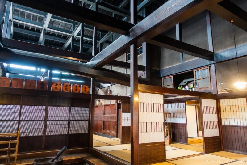A traditional Japanese interior inspired by Kusakabe Heritage House, with wooden beams, tatami mat floors, sliding shoji doors, and a raised ceiling. Natural light fills the space, highlighting its classic design features.