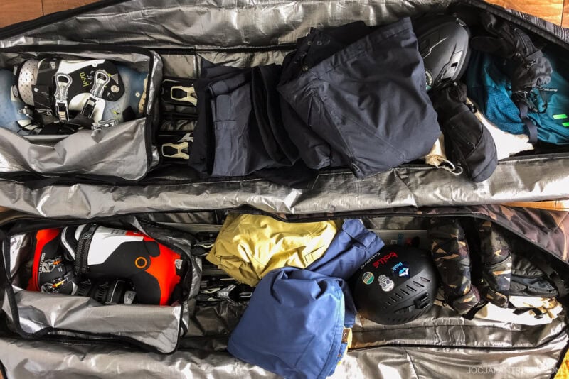 Two open Utah ski bags containing ski boots, helmets, gloves, jackets, pants, and other winter gear, all neatly packed and organized for a snow sports trip.