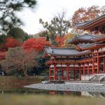 Visiting Byodoin Temple: Kyoto’s Iconic 10-Yen Coin Temple in Uji Traditional Japanese temple with ornate red and white architecture beside a calm pond, surrounded by vibrant autumn trees with red and orange leaves—this is the iconic Byodoin Temple in Uji, Kyoto.